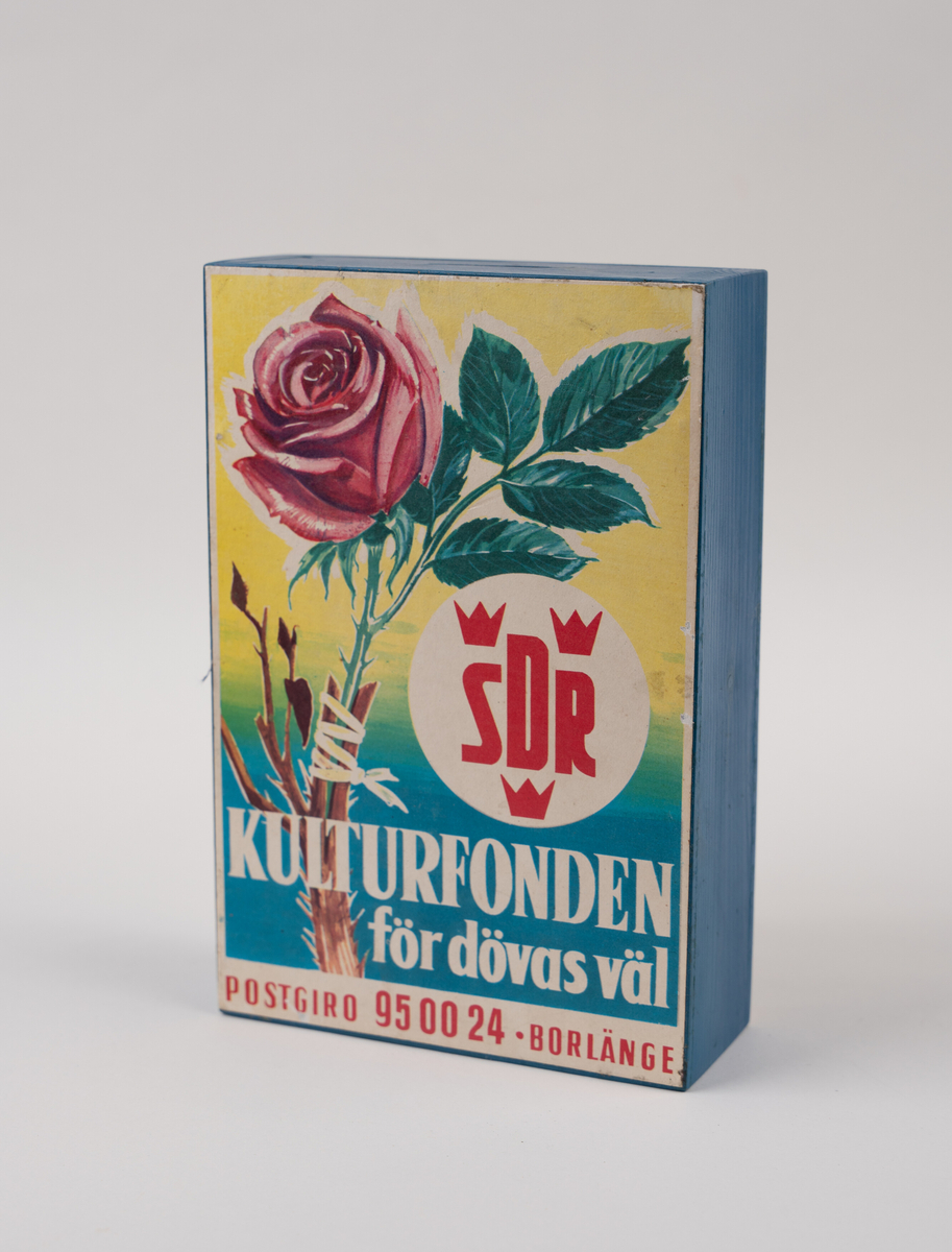 Rektangulär insamlingsbössa i trä, målad i blått med en tryckt etikett på framsidan.